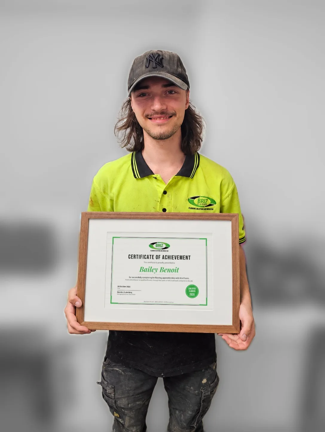 Bailey holding his framed Briz Floors Certificate of Achievement