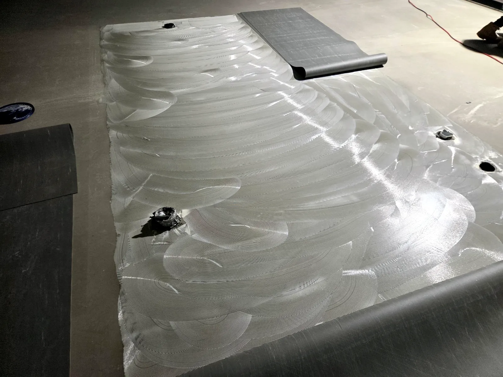 Adhesive trowelled out with a vinyl sheet rolling on at Coles Annerley